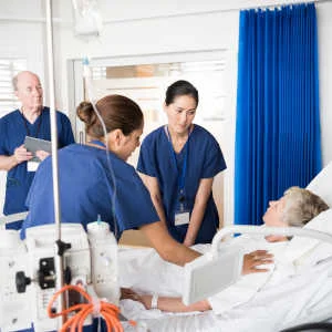 senior-in-hospital-bed-with-staff